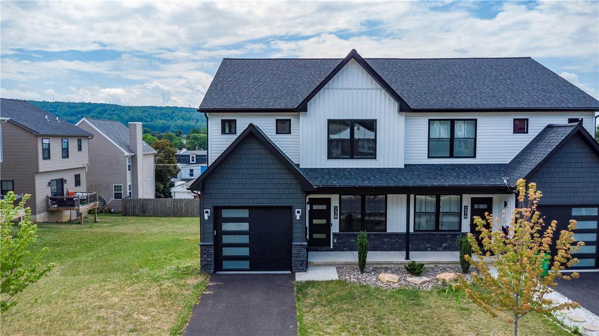 Image 2: Modern facade with a sleek black garage door and a