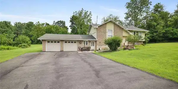 Image 3: Mature trees frame a classic split-level exterior