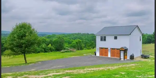 Image 2: An detached garage with a metal roof overlooks rol