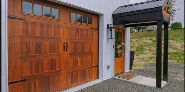 Image 4: A natural wood-tone carriage garage door sits adja