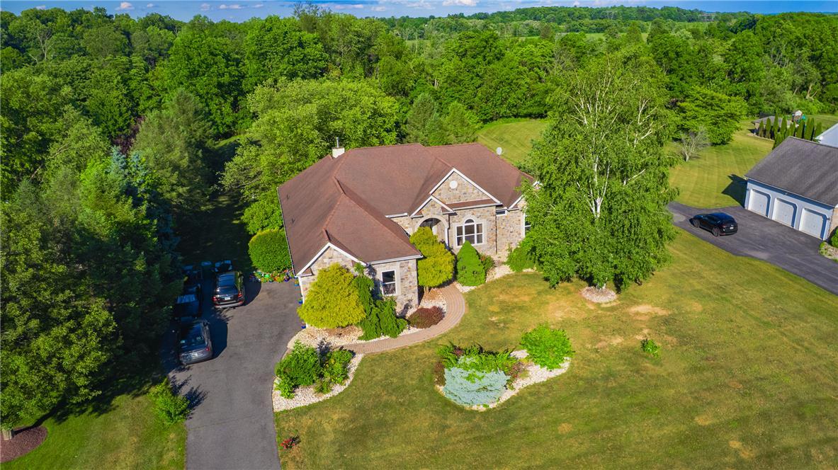Image 1: A grand stone facade home nestled amidst verdant l