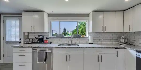 Image 3: A well-appointed kitchen features ample white cabi