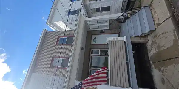 Image 2: A well-maintained facade features light-colored si