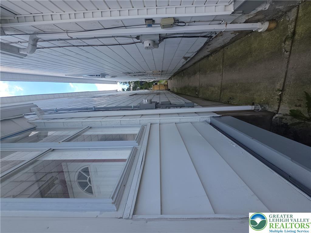 Image 4: View the narrow concrete pathway between two struc