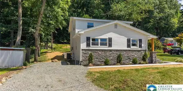 Image 4: A quaint residence featuring stone and siding cons