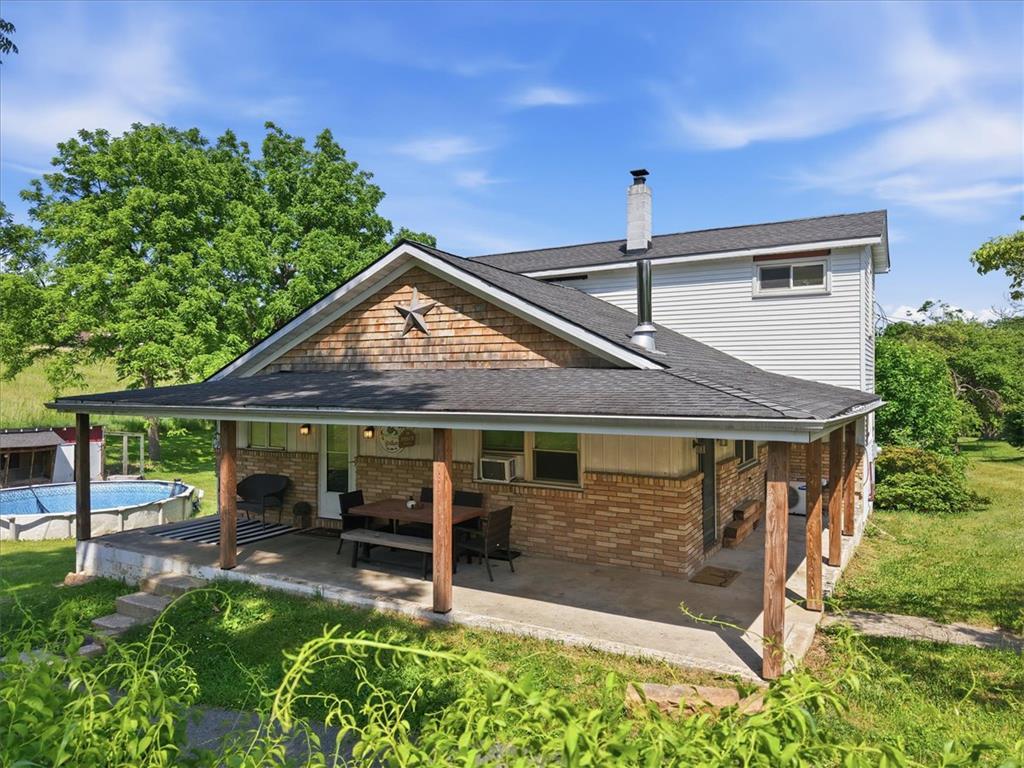 Image 2: An inviting porch and an above-ground pool define