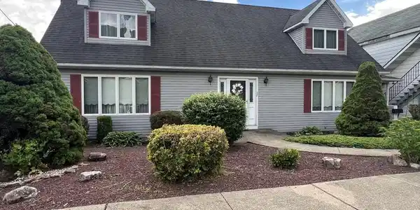 Image 2: A well-maintained facade with neat landscaping and
