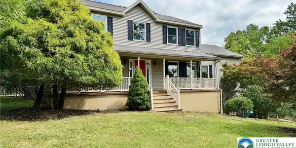Image 2: A welcoming front porch with white railings graces