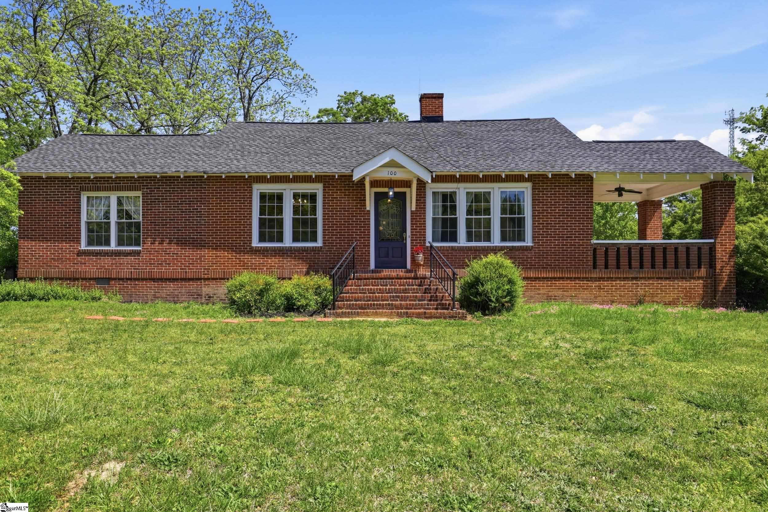 Image 2: Charming all-brick home with classic curb appeal, set on a spacious lot with mature trees and a welcoming front entry.