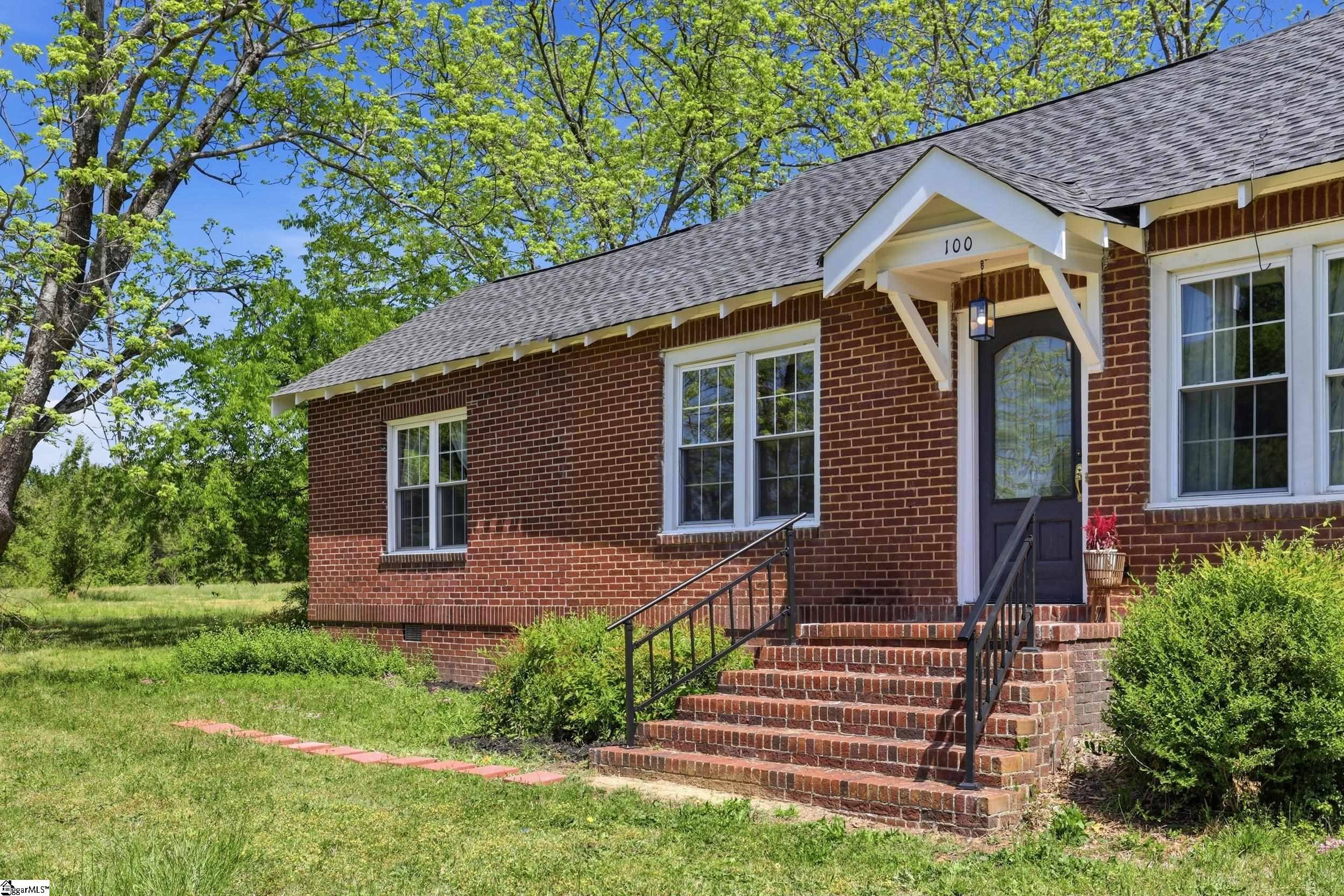 Image 3: Inviting front entrance with brick steps, covered porch, and timeless architectural details.
