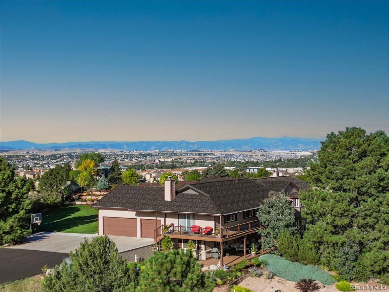Image 1: Elevated 4.5-acre homesite with sweeping Front Range and city views, showcasing the walk-out ranch, expansive decking, and private setting just minutes from downtown Parker.