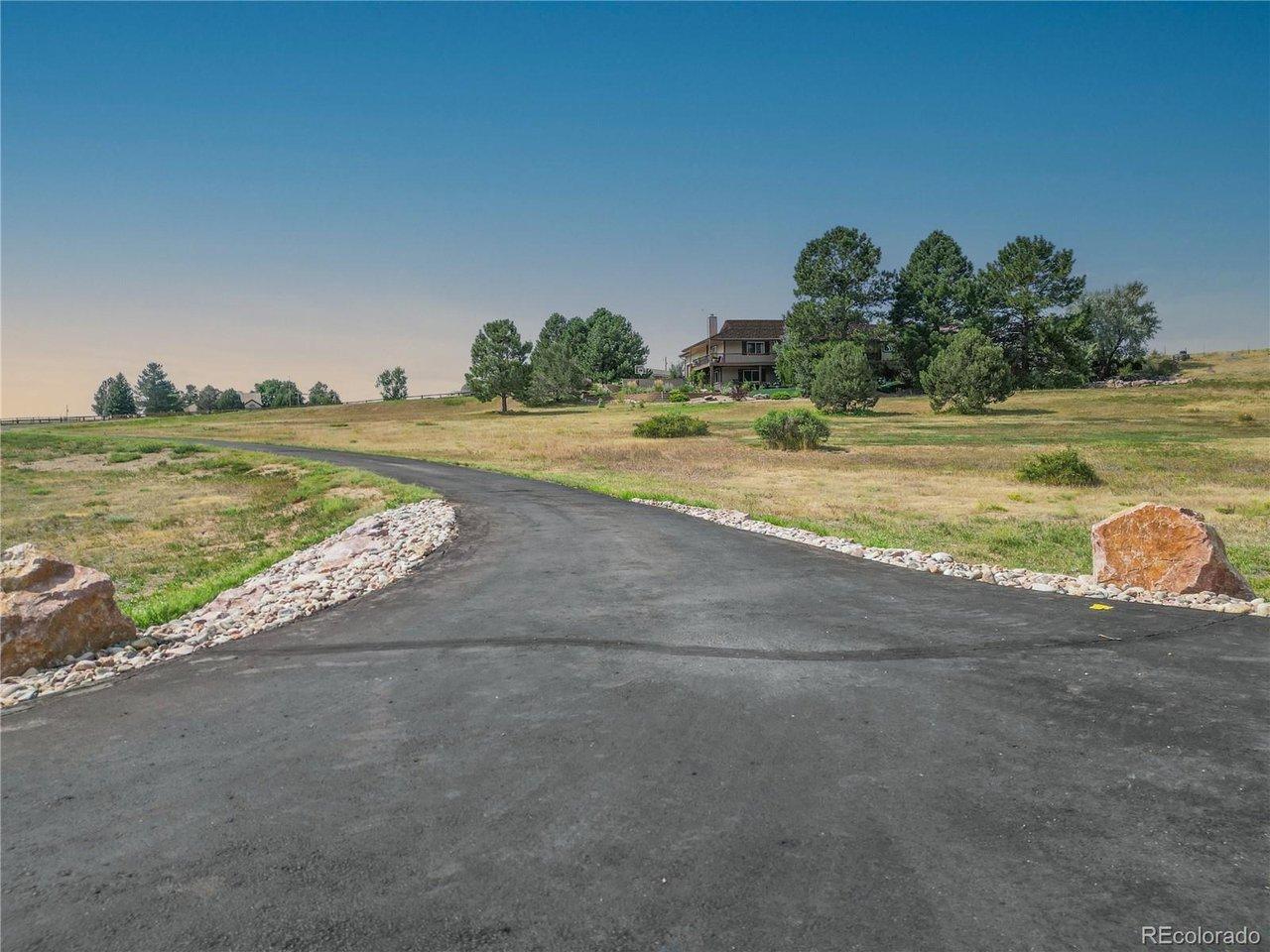 Image 3: Long, paved driveway approach winding through usable acreage, creating a private and impressive arrival experience.