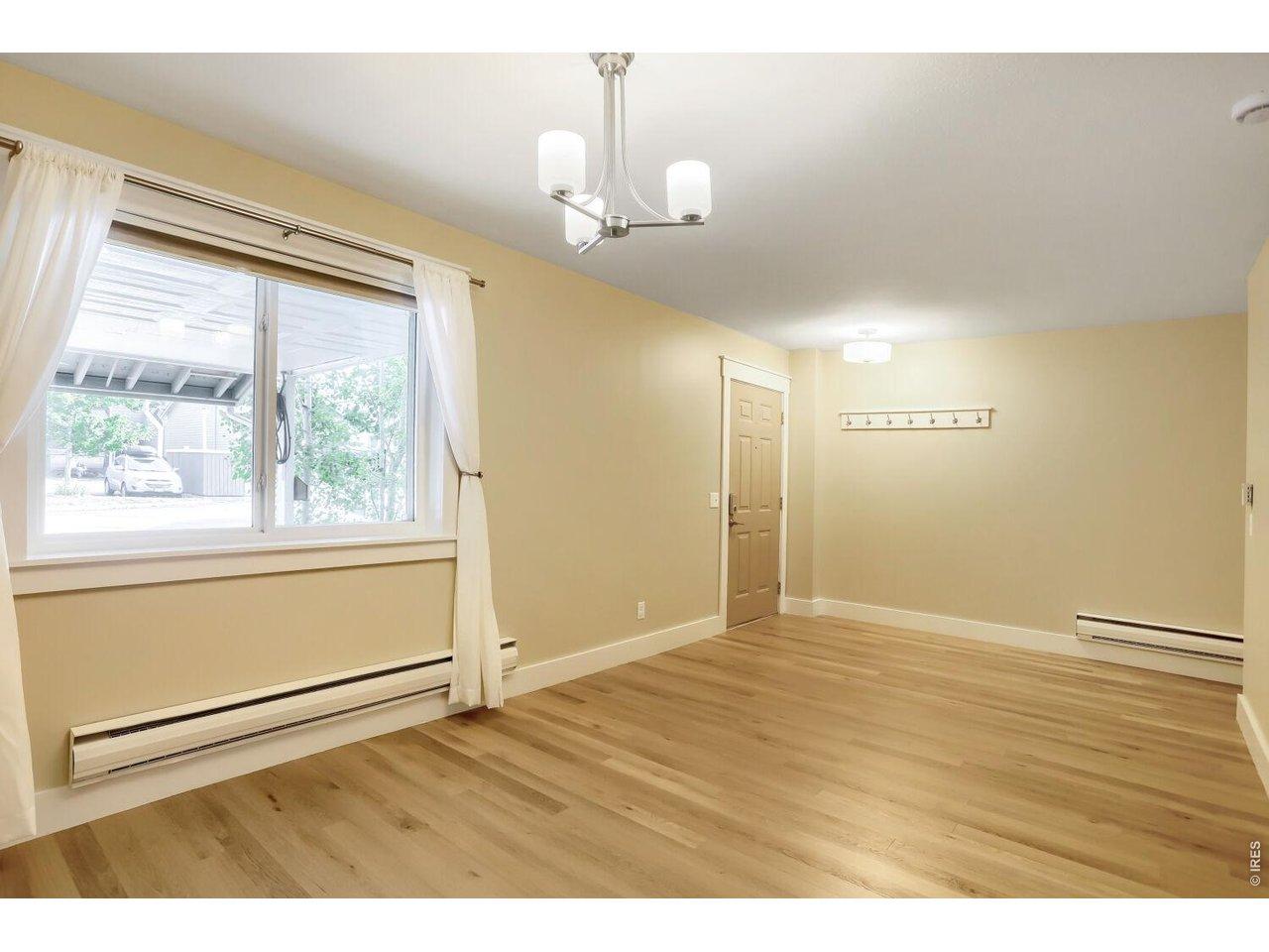Image 3: Enter into the main level and enjoy fresh paint and newer LVP flooring throughout, with natural light