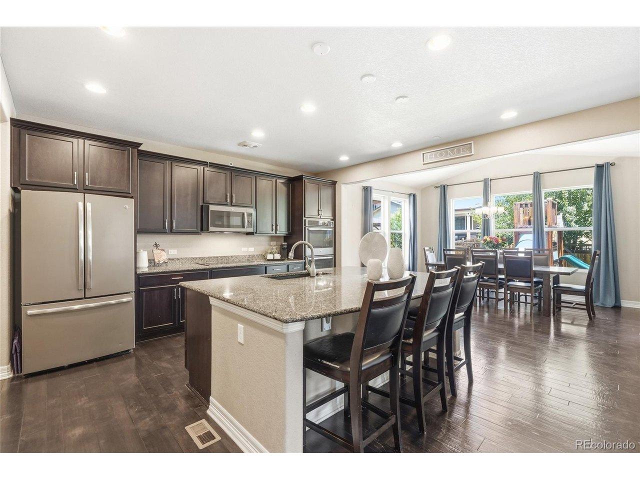 Image 3: Gather and cook in the open-concept kitchen with granite island, dark cabinets and double ovens at 3320 Empire Ave, Frederick CO Image 3: Gather and cook in the open-concept kitchen with granite island, dark cabinets and double ovens at 3320 Empire Ave, Frederick CO