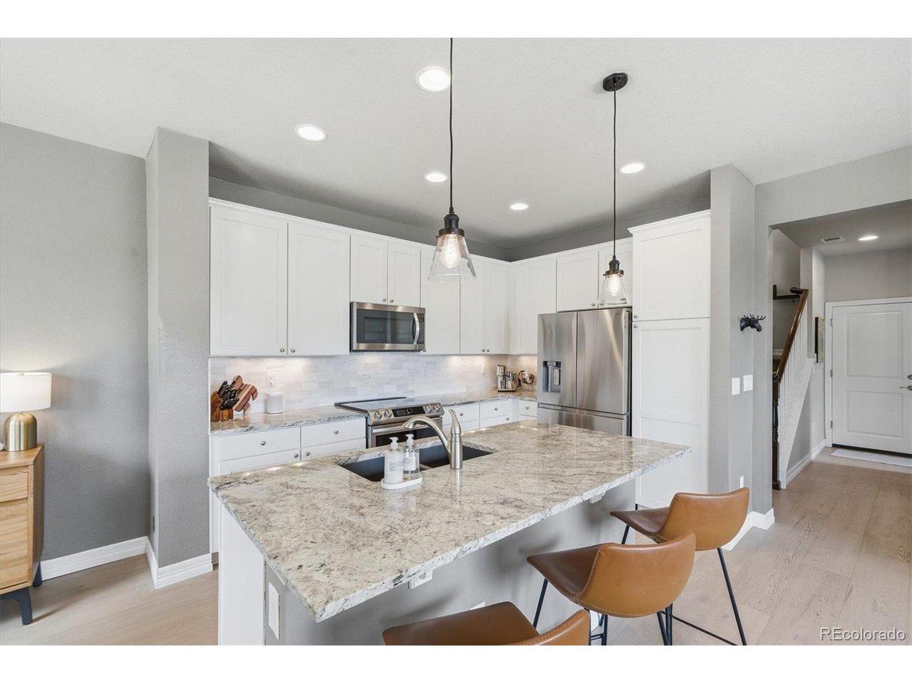 Image 3: Open-concept kitchen with oversized island, pantry, and bar seating Image 3: Open-concept kitchen with oversized island, pantry, and bar seating