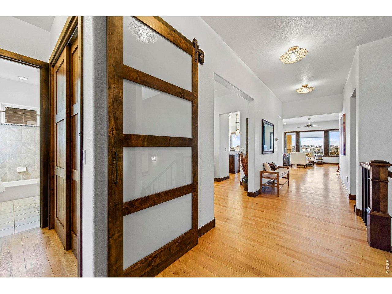 Image 3: Welcoming foyer featuring rich hardwood floors and sliding barn door into bedroom/study Image 3: Welcoming foyer featuring rich hardwood floors and sliding barn door into bedroom/study