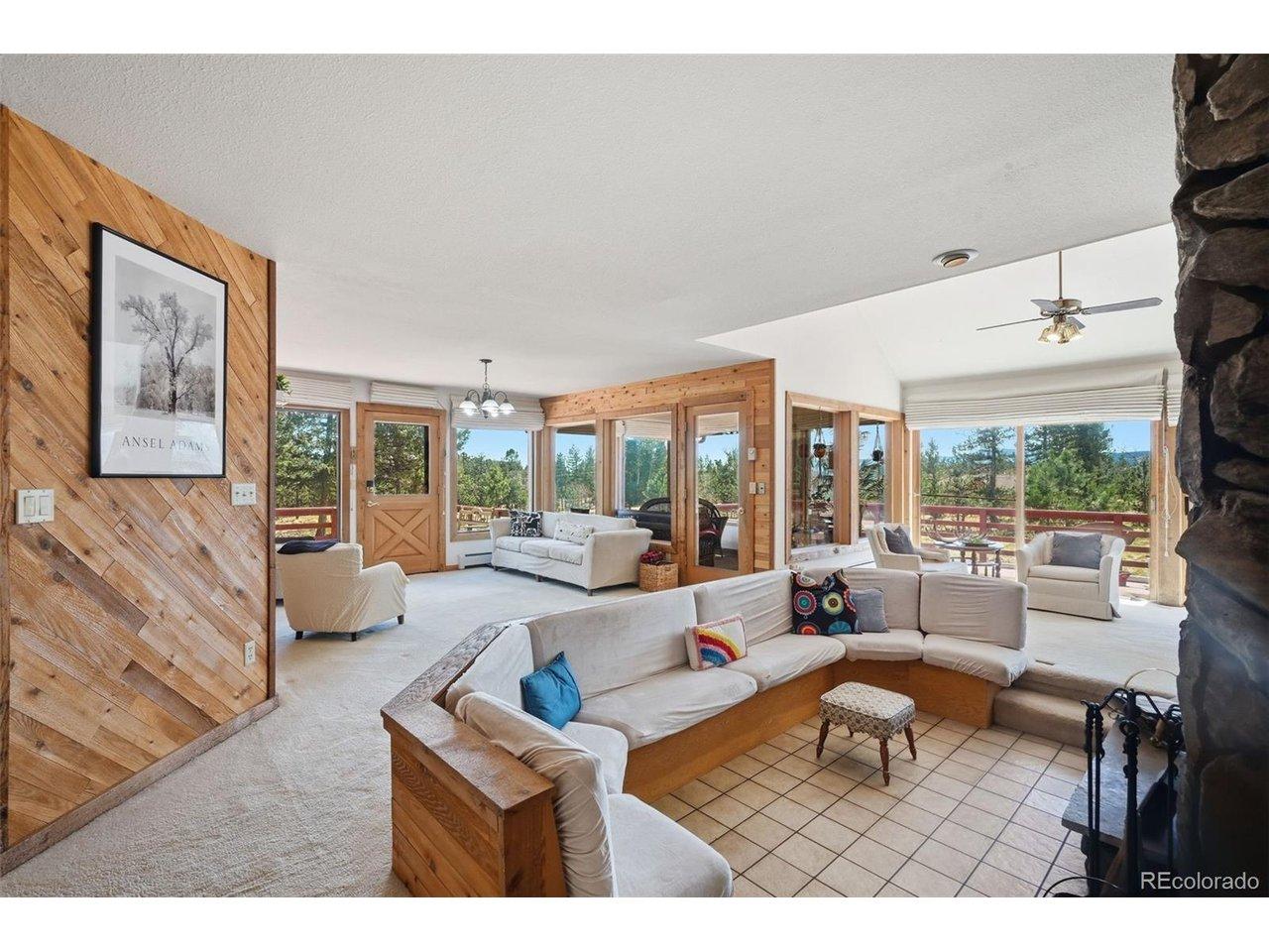 Image 4: Main living area features a sunken bench seating area around a wood-burning fireplace!