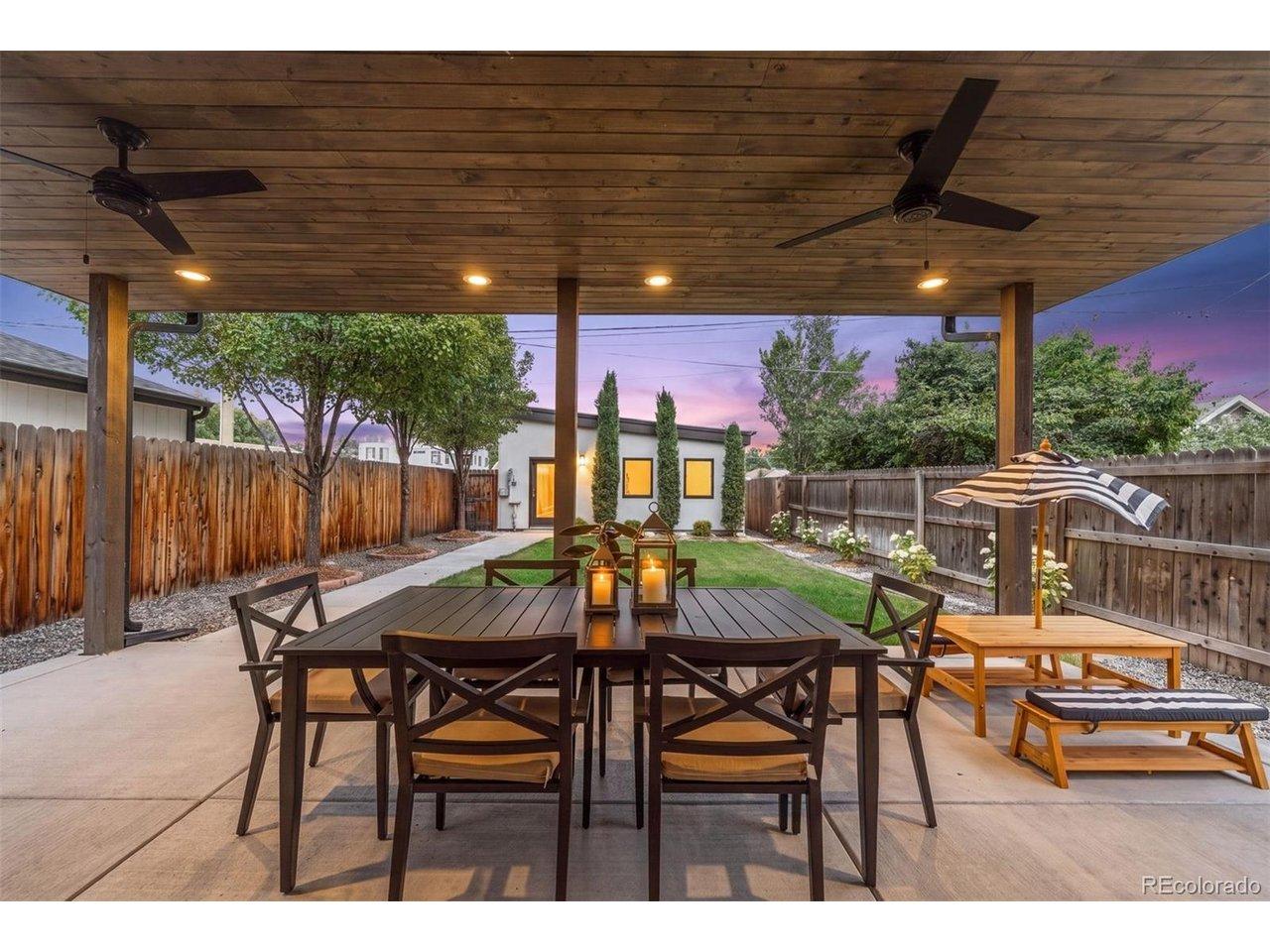 Image 2: Covered patio with ceiling fans, speakers, and a gas line for effortless entertaining.