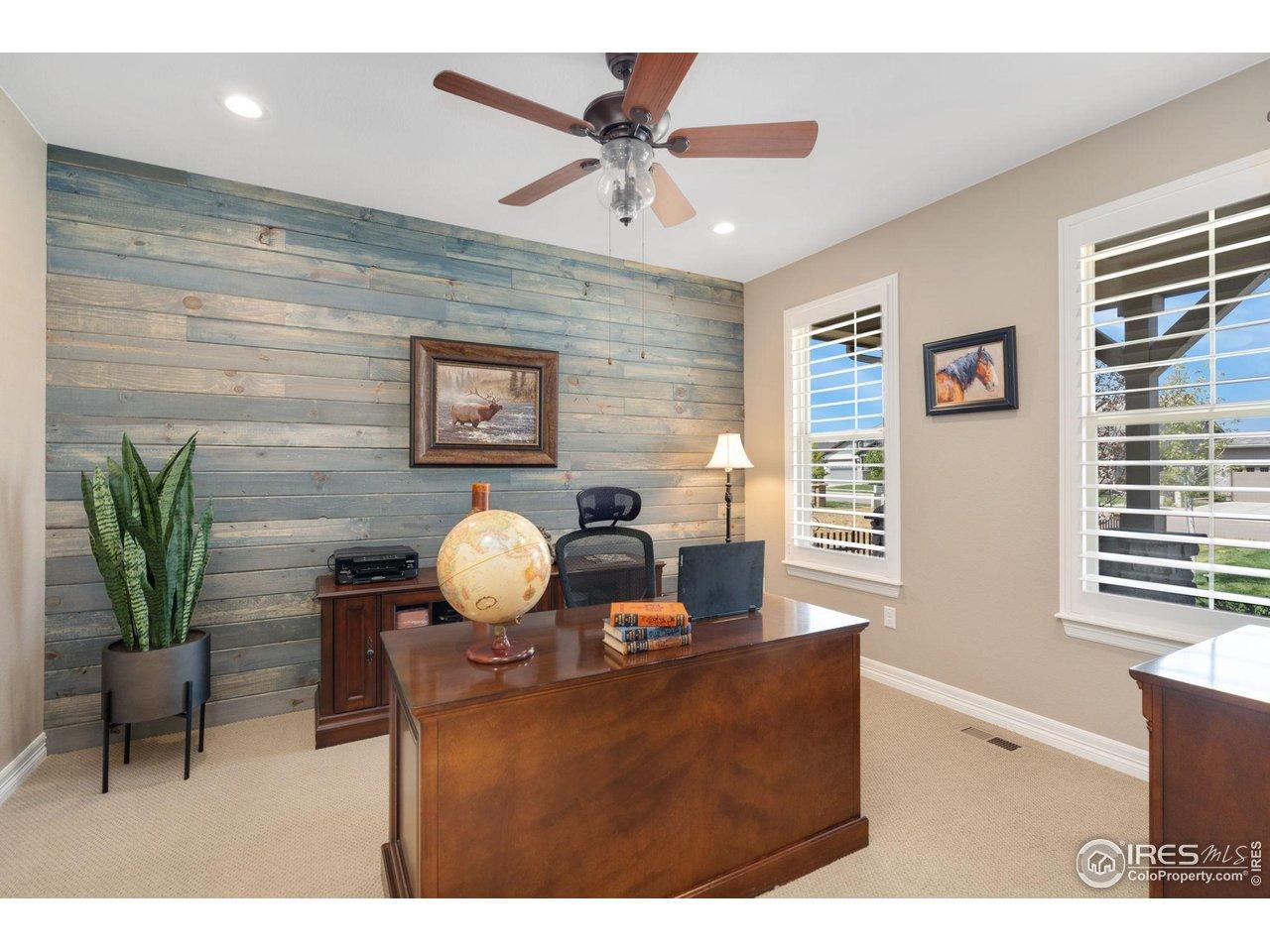 Image 4: Main floor office highlighted by a modern shiplap accent wall and Blinds by Design plantation shutters! Image 4: Main floor office highlighted by a modern shiplap accent wall and Blinds by Design plantation shutters!