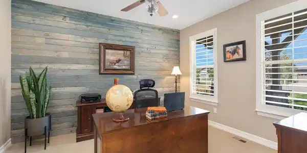 Image 4: Main floor office highlighted by a modern shiplap accent wall and Blinds by Design plantation shutters! Image 4: Main floor office highlighted by a modern shiplap accent wall and Blinds by Design plantation shutters!