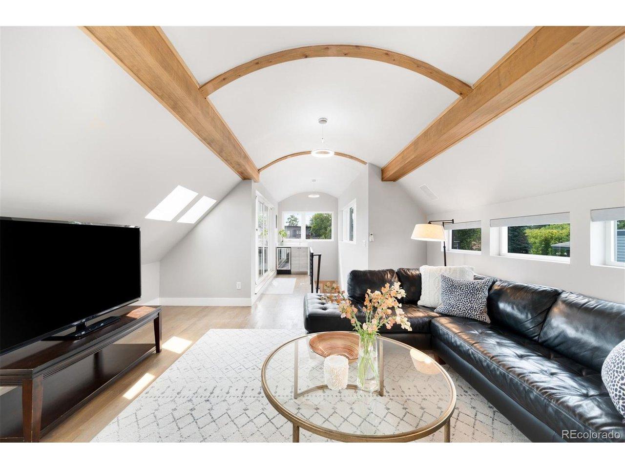 Image 4: The third floor is an entertaining destination with wood-beam ceilings, skylights, a wet bar with beverage refrigerator.