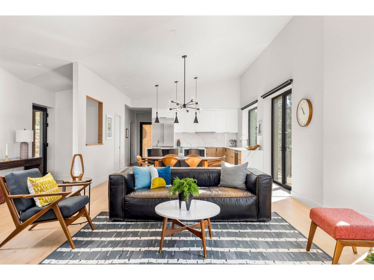 Image 3: High ceilings and expansive windows bring light and mountain views into the open-concept living, dining, and kitchen spaces. Image 3: High ceilings and expansive windows bring light and mountain views into the open-concept living, dining, and kitchen spaces.