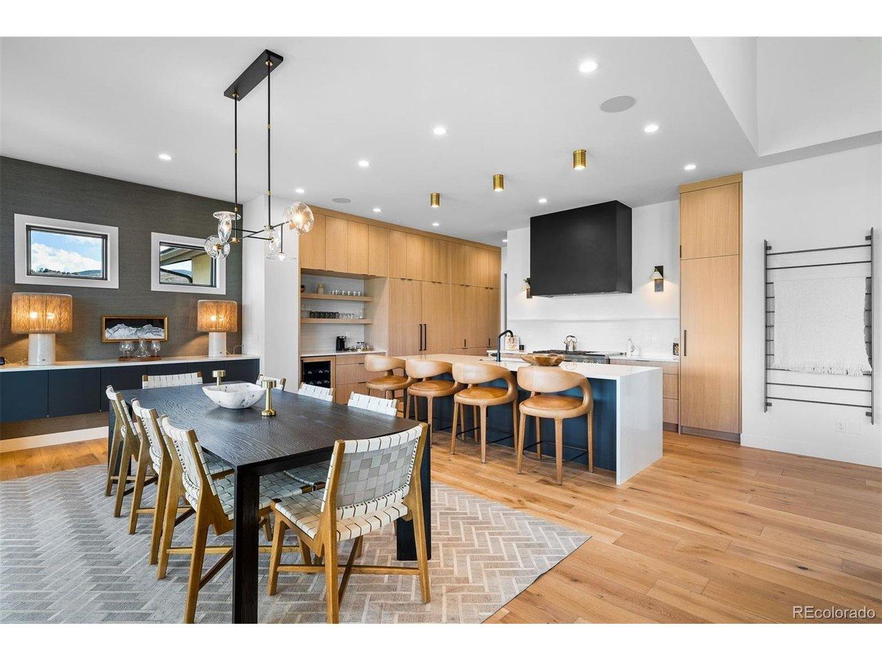 Image 3: Open-concept dining anchored by custom cabinetry and a quartz waterfall island. Image 3: Open-concept dining anchored by custom cabinetry and a quartz waterfall island.