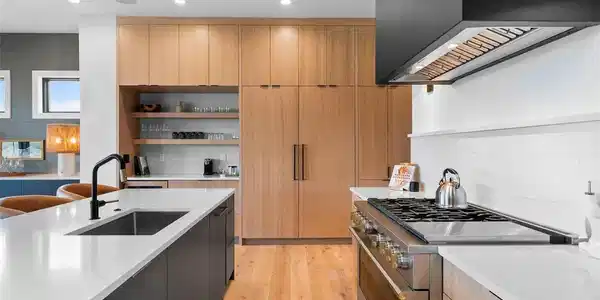 Image 4: Monogram range framed by white oak cabinetry and clean-lined finishes.