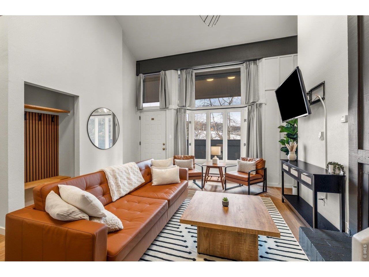 Image 3: Bathed in natural light with soaring ceilings and premium finishes throughout, this stunning great room is the heart of an exceptional mountain retreat. Also features a built-in closet for gearing up!