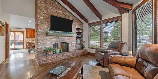 Image 4: The brick floor to ceiling fireplace with raised hearth and built-in display niches anchors the living room while creating a striking focal point. Image 4: The brick floor to ceiling fireplace with raised hearth and built-in display niches anchors the living room while creating a striking focal point.