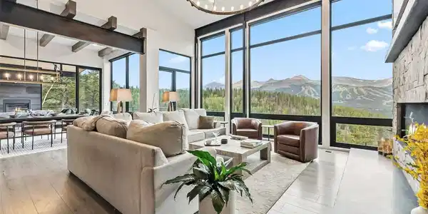 Image 2: Warm and inviting Great Room with chandelier, beam ceiling and expansive views of Peak 1 to Quandary Peak.