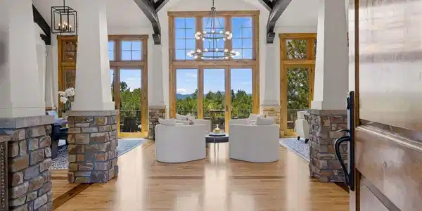 Image 3: A striking foyer welcomes you with soaring ceilings, exposed timber trusses, stone accents and mountain views framed through walls of windows. Image 3: A striking foyer welcomes you with soaring ceilings, exposed timber trusses, stone accents and mountain views framed through walls of windows.
