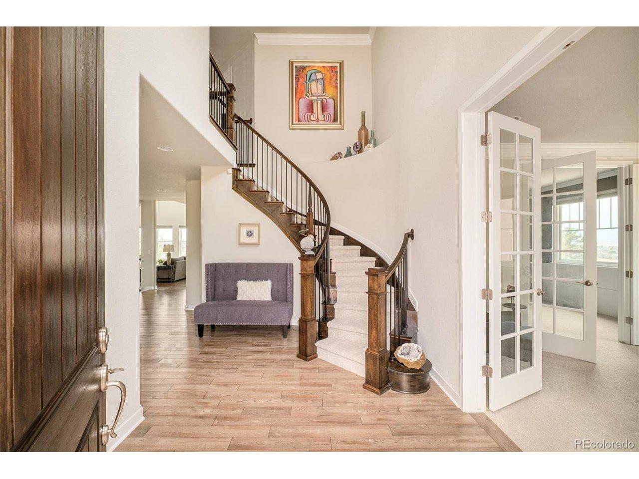 Image 3: Grand entry with soaring ceilings, curved staircase, and warm wood flooring creates a stunning first impression Image 3: Grand entry with soaring ceilings, curved staircase, and warm wood flooring creates a stunning first impression