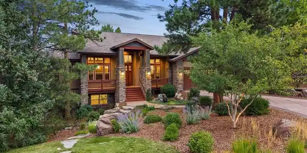 Image 2: Stunning custom home in Escavera, Castle Rock, situated on a large corner lot surrounded by mature pine trees, beautiful landscaping and a grand covered front entry.
