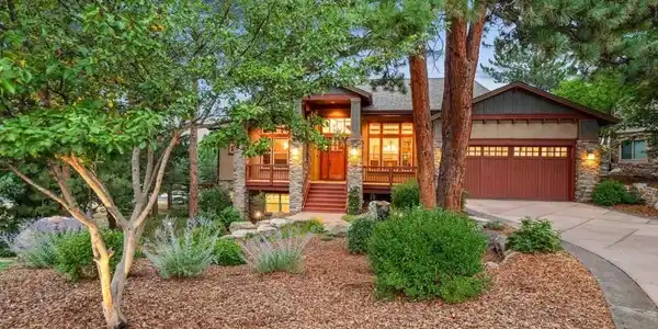 Image 3: Beautiful mature trees surround this stunning Escavera custom home, set back on the large corner lot for added privacy. A tranquil front water feature creates a serene and welcoming setting.