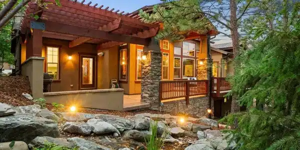 Image 4: Expansive outdoor living spaces surrounded by mature trees and a second beautiful water feature create a peaceful, tranquil setting perfect for relaxing and entertaining.
