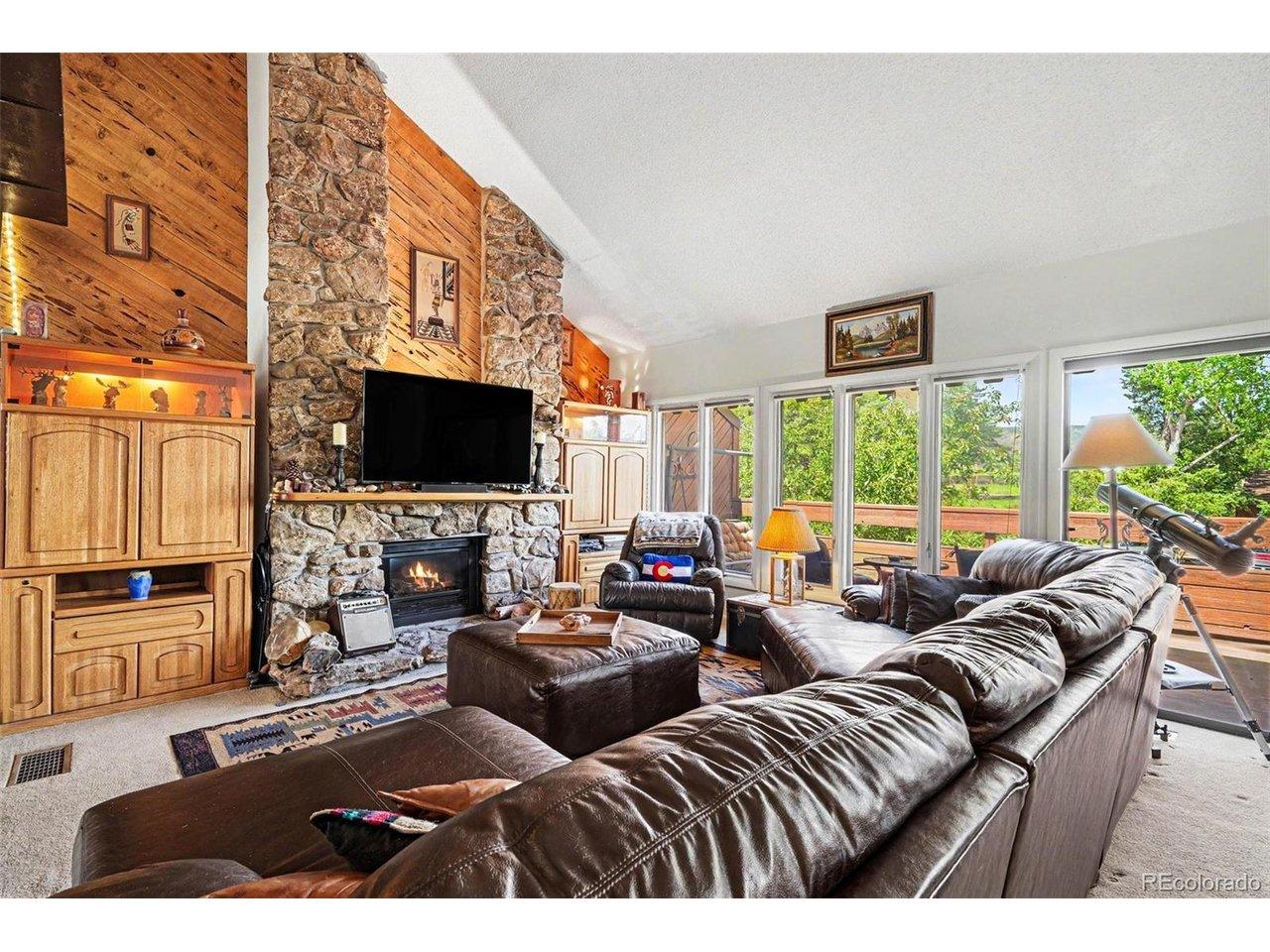 Image 2: Living room highlights a stone gas fireplace with stunning mountain ambiance Image 2: Living room highlights a stone gas fireplace with stunning mountain ambiance