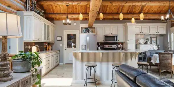 Image 3: The creamy white cabinetry, light flooring, and abundant skylights make this log home feel light and bright. Image 3: The creamy white cabinetry, light flooring, and abundant skylights make this log home feel light and bright.