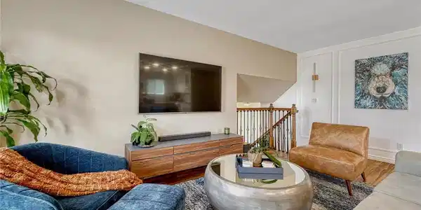 Image 4: Perfect for a quiet evening at home, the main-level living room accommodates comfortable seating and a wall-mounted TV, all cooled efficiently by the newer central AC Image 4: Perfect for a quiet evening at home, the main-level living room accommodates comfortable seating and a wall-mounted TV, all cooled efficiently by the newer central AC