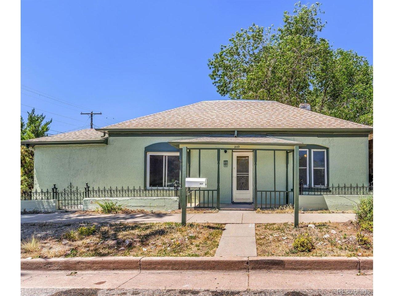 Image 2: Mint green stucco exterior with a covered front porch