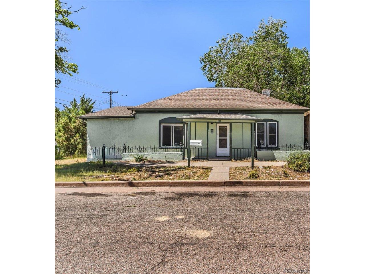 Image 3: Exterior featuring a covered front porch with railings, stucco siding, and a fenced front yard