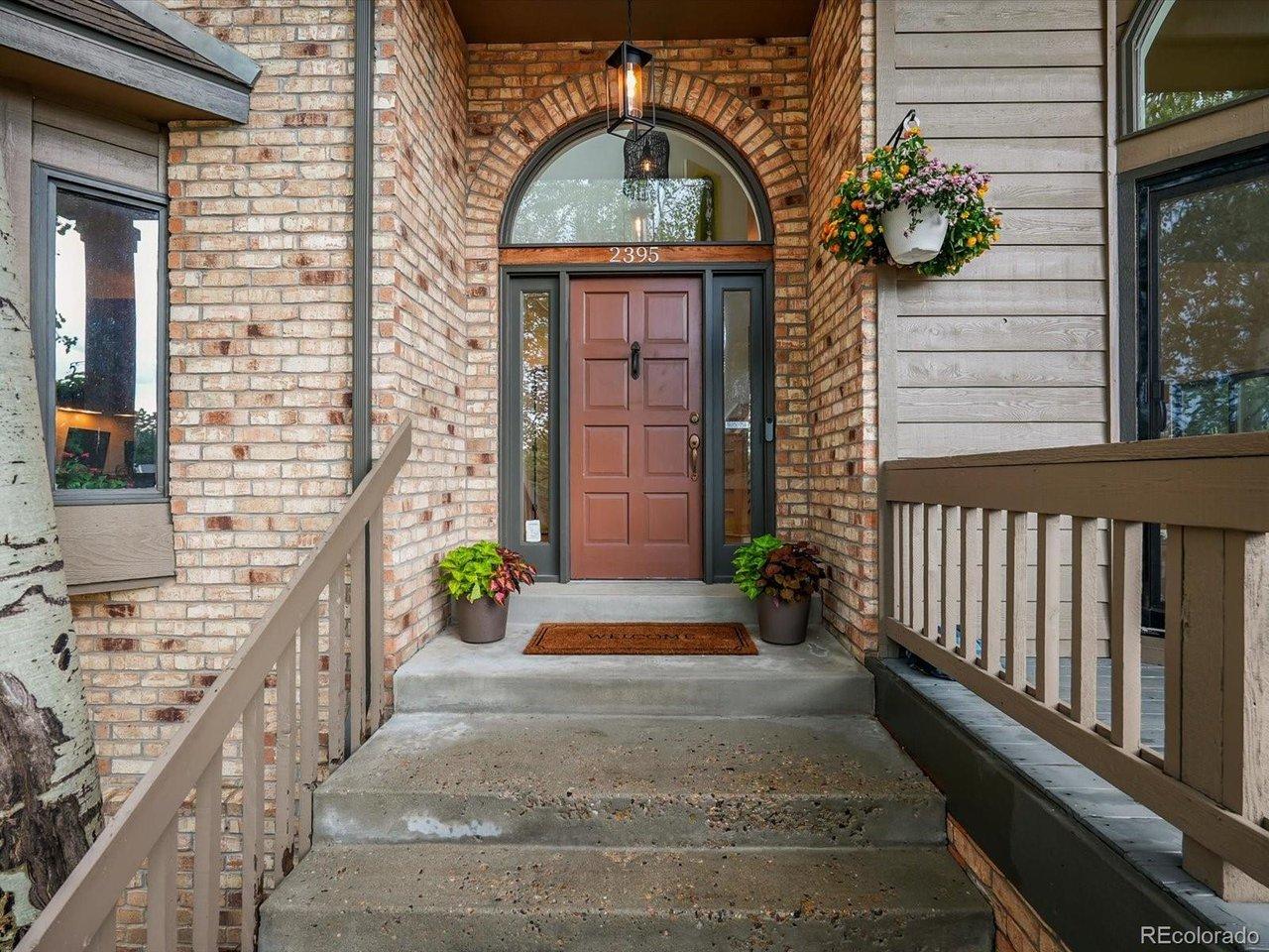 Image 4: Covered front porch with brick columns and an arched wood entry door welcomes you home.
