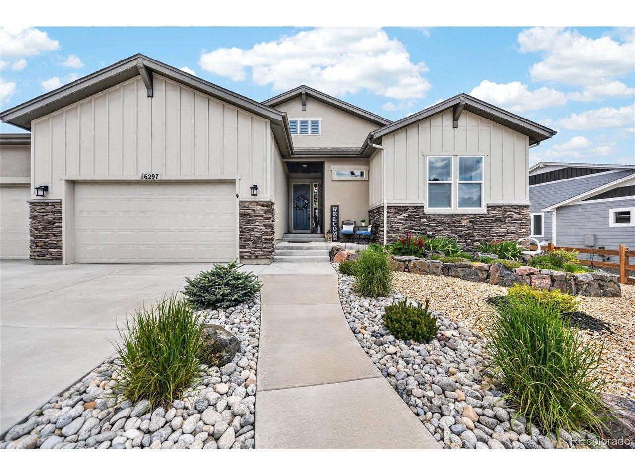 Image 3: Contemporary exterior featuring board and batten siding, stone accents, a concrete driveway, and a zero-scaped front yard with a curved concrete pathway Image 3: Contemporary exterior featuring board and batten siding, stone accents, a concrete driveway, and a zero-scaped front yard with a curved concrete pathway