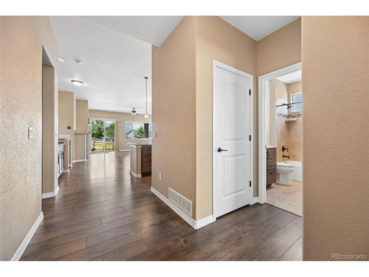 Image 2: Wood-finish flooring extending from the entryway into an open-concept living area Image 2: Wood-finish flooring extending from the entryway into an open-concept living area