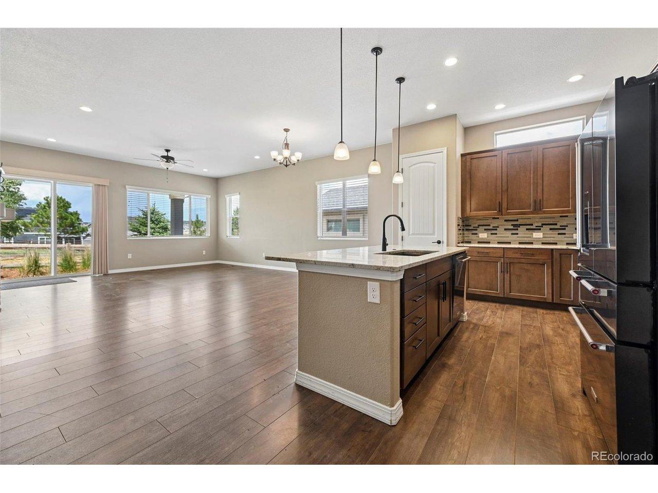 Image 3: Open-concept kitchen and living area featuring wood-finish flooring, recessed lighting, and a kitchen island with pendant lighting Image 3: Open-concept kitchen and living area featuring wood-finish flooring, recessed lighting, and a kitchen island with pendant lighting