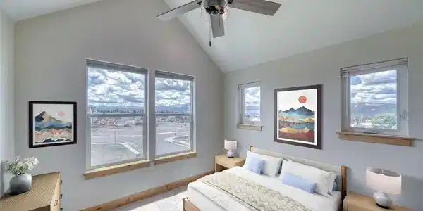 Image 4: Virtually staged primary bedroom on 3rd floor with vaulted ceiling and big views