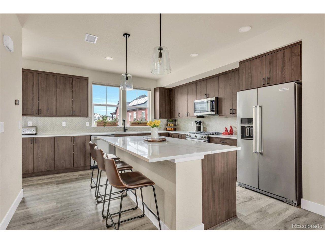 Image 1: Extended kitchen, quartz counters, designer tile backsplash, Upgraded KitchenAid appliances Image 1: Extended kitchen, quartz counters, designer tile backsplash, Upgraded KitchenAid appliances