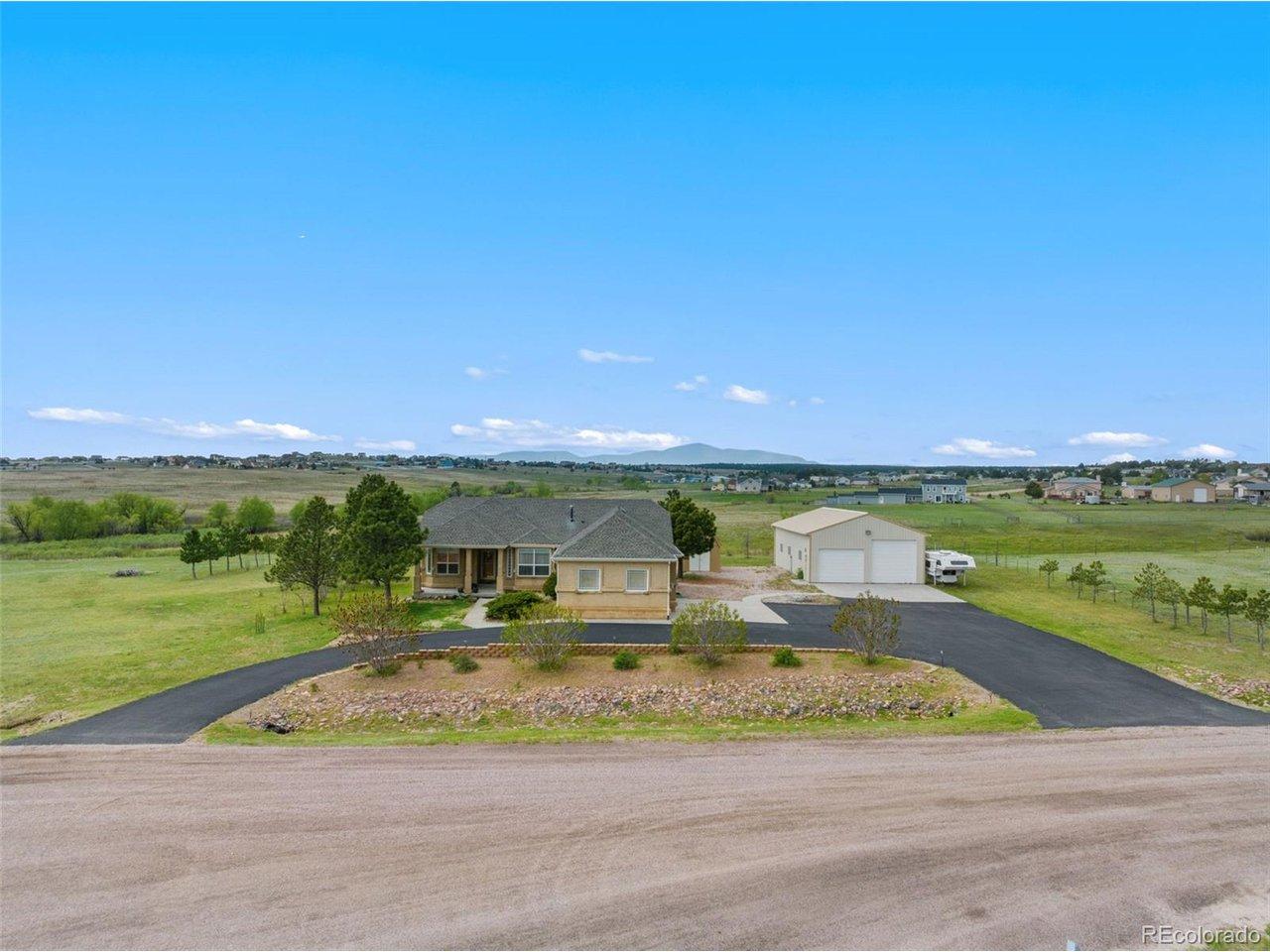 Image 1: Beautiful stucco home with attached 3-car garage, large shop, storage shed, 1/2 circle asphalted driveway and view of Pikes Peak.