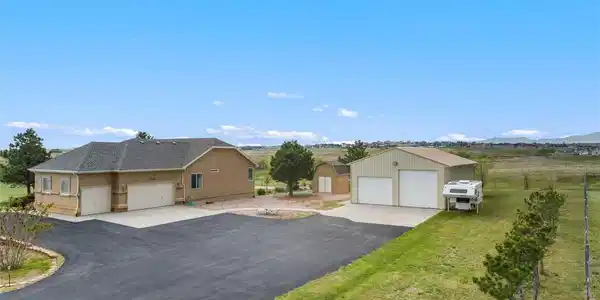 Image 2: Side entry of home with asphalt driveway, 3-car attached garage, small shed and large shop with RV garage door. Image 2: Side entry of home with asphalt driveway, 3-car attached garage, small shed and large shop with RV garage door.