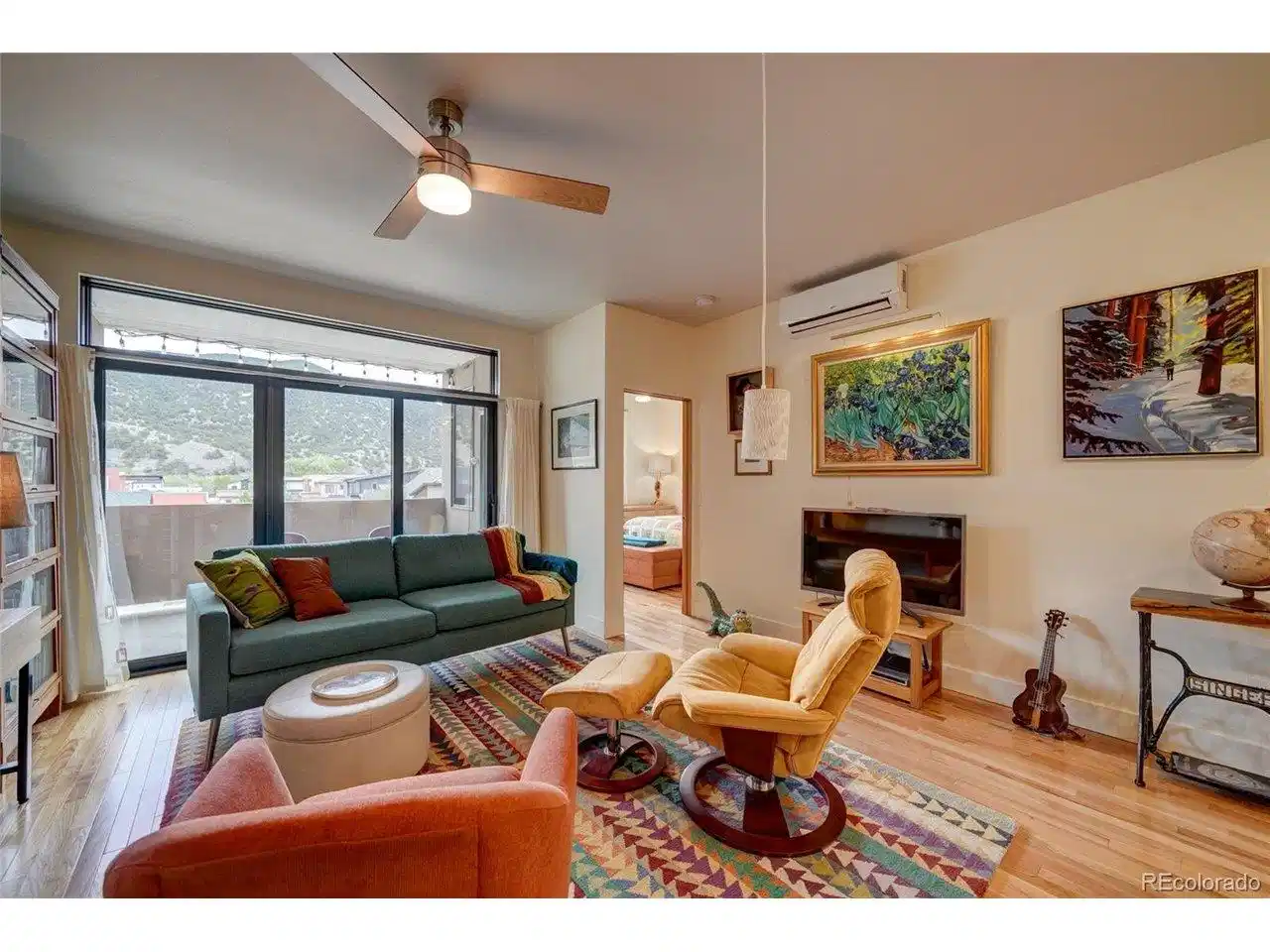 Image 1: Living room opens out to the deck, mountain views and into the primary suite.